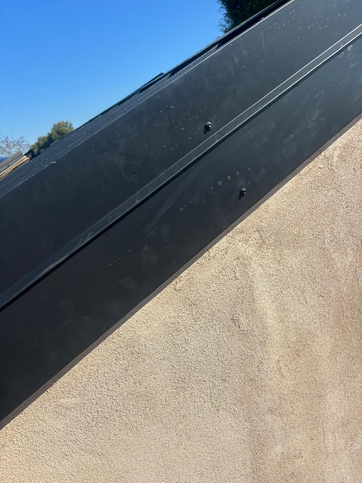 New black metal fascia wrap installed over a San Diego roof edge with hemmed drip edge