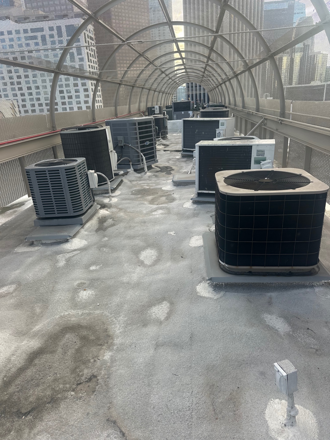 Row of HVAC condensers on a commercial flat roof in downtown San Diego