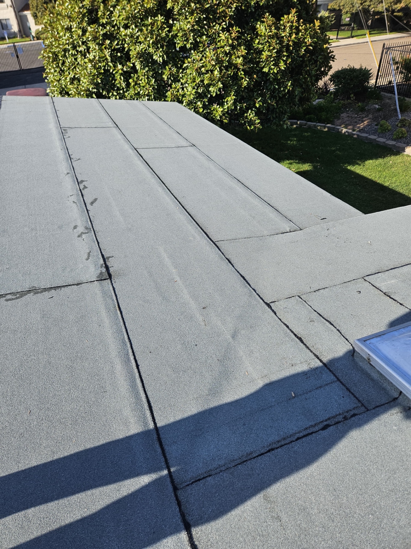 Completed insulated low-slope roof around skylight and transition details