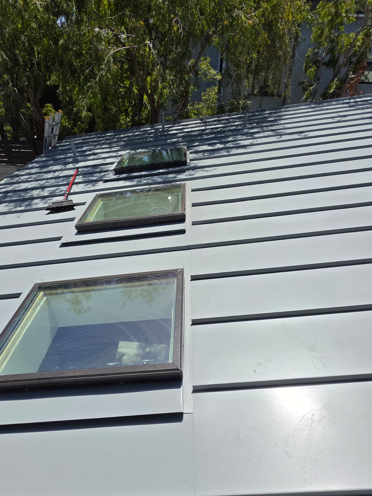 Three skylights installed in a standing seam metal roof on a San Diego residence