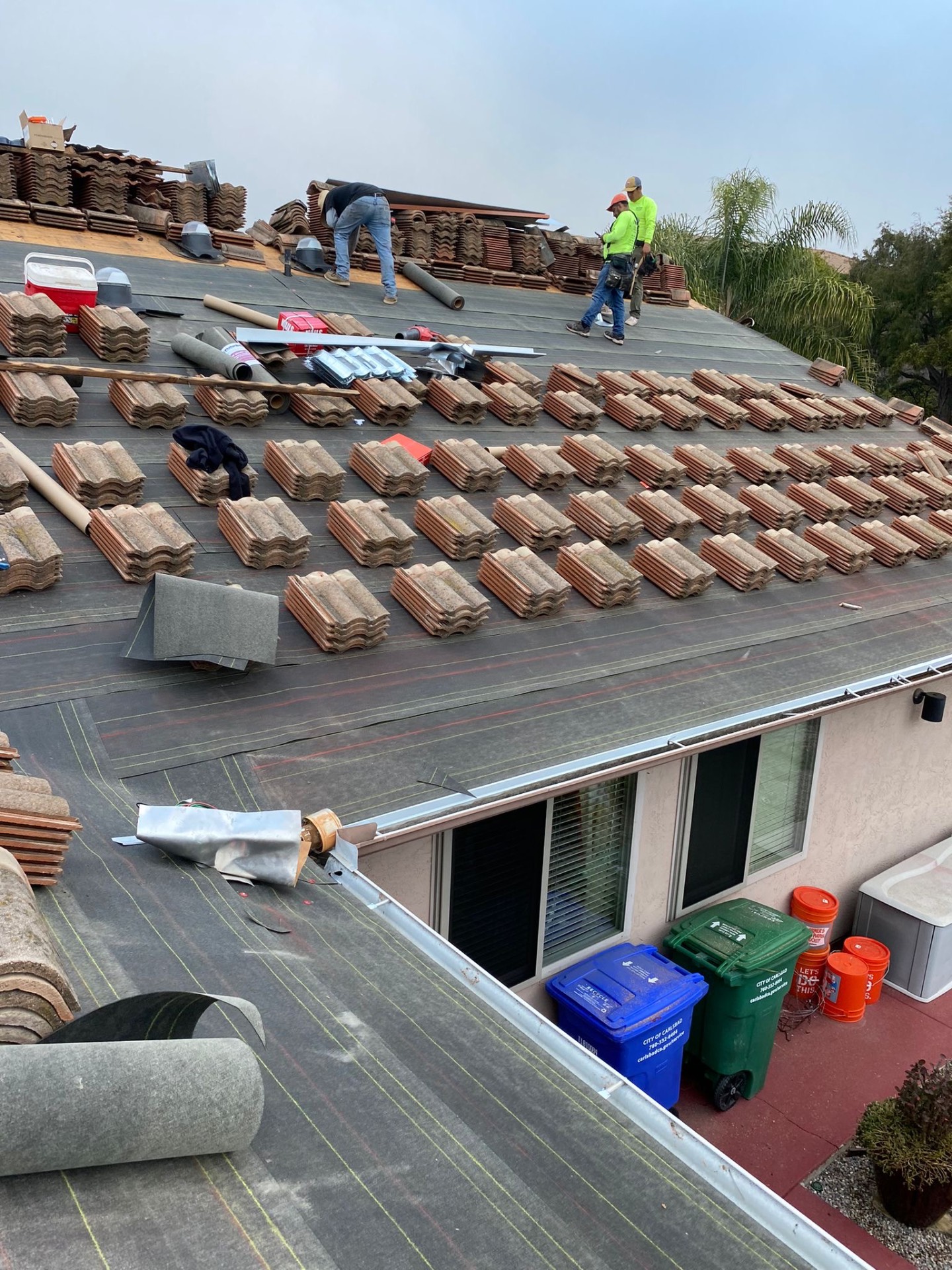 California First Roofing crew loading and spacing roof tile on a Carlsbad tile roof
