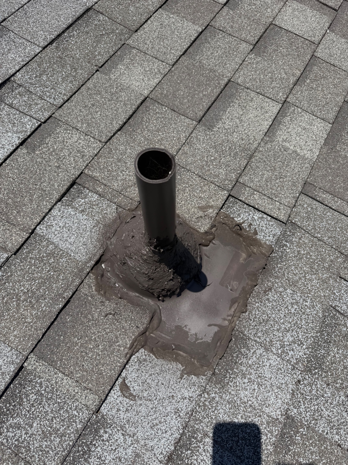 Plumbing vent pipe sealed with globs of roof mastic instead of a proper flashing boot