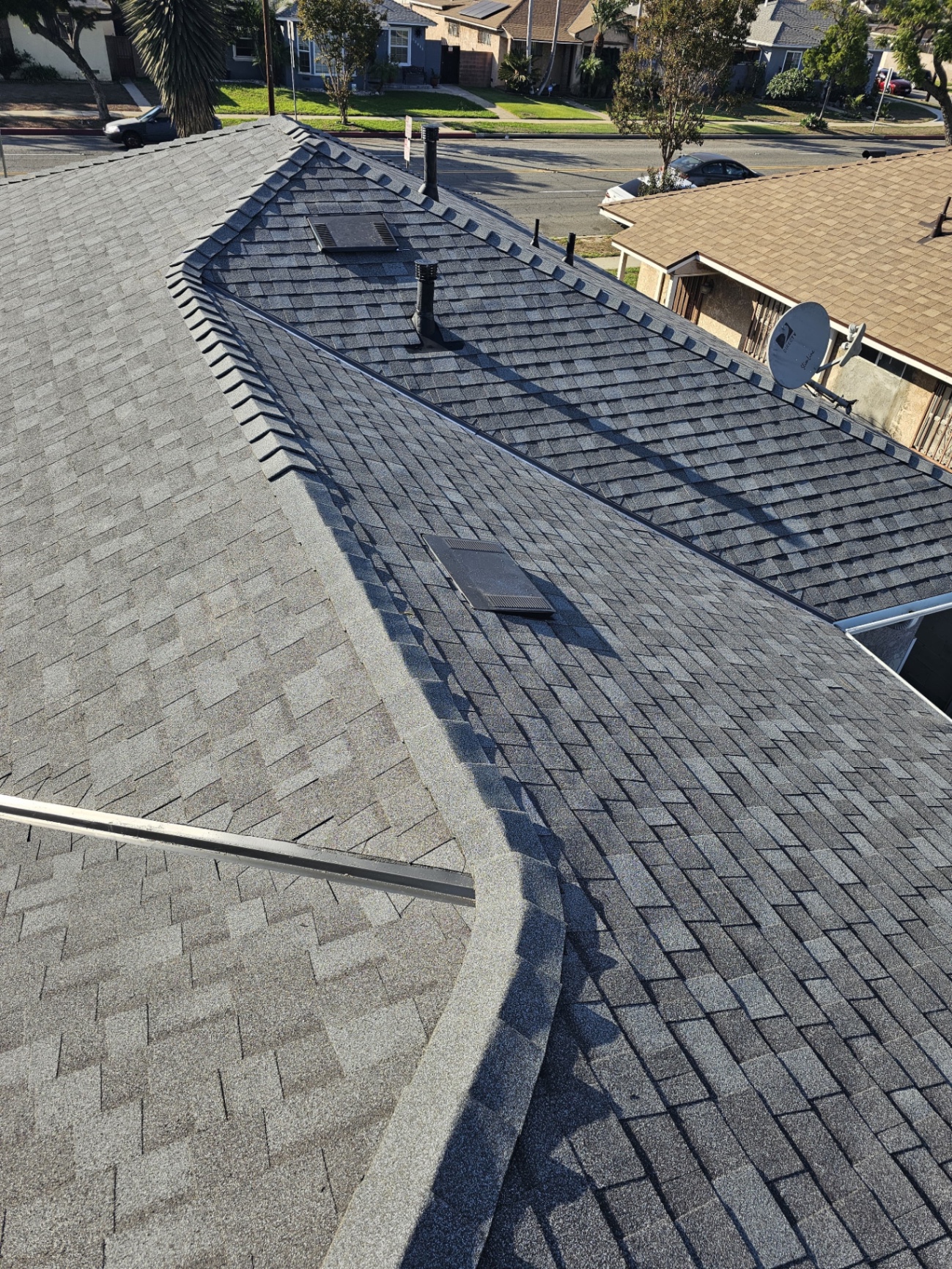 Completed gray architectural shingle roof with hip and ridge cap in San Diego