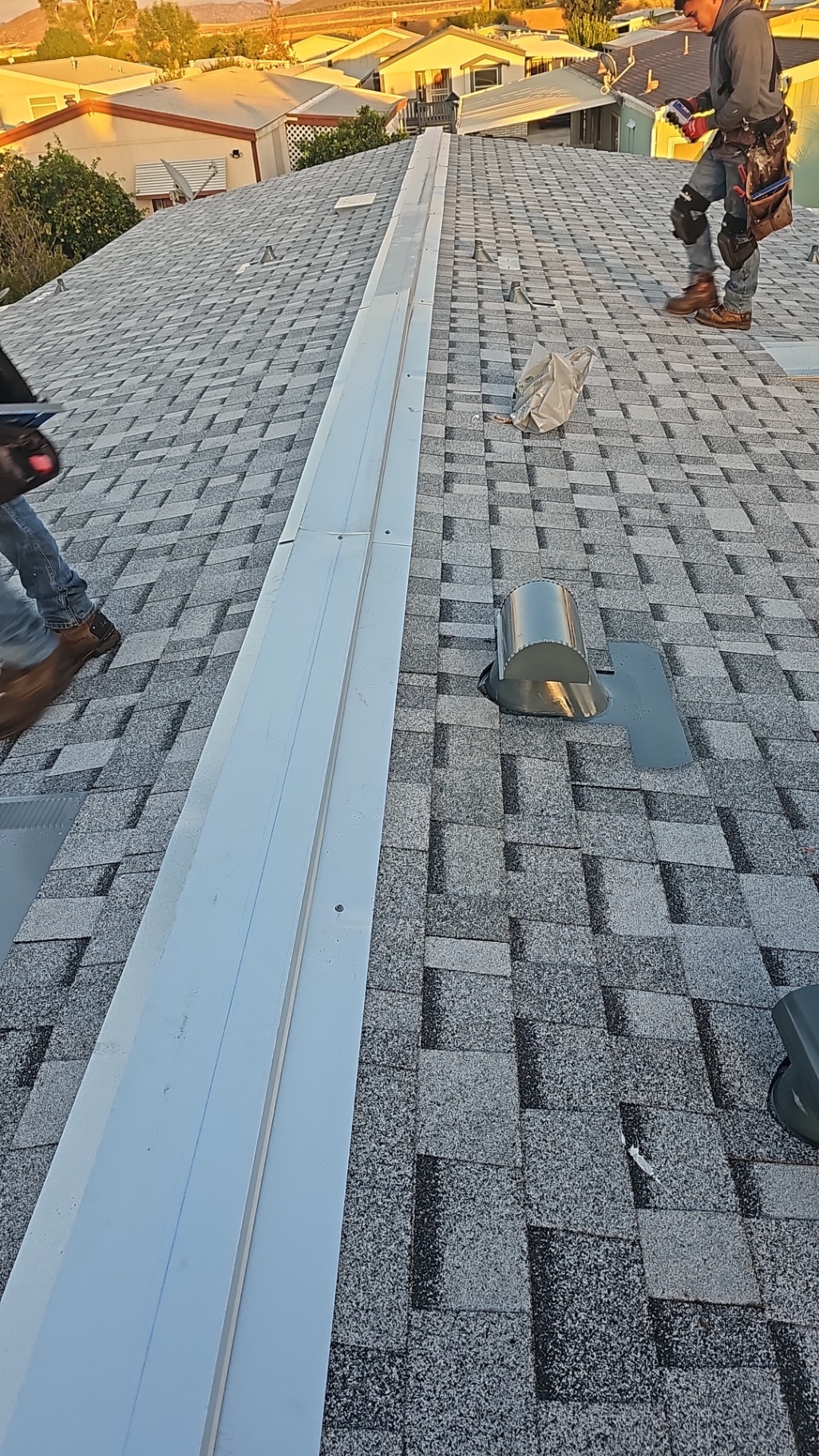 California First Roofing crew installing ridge vent and pipe flashings on a San Diego roof