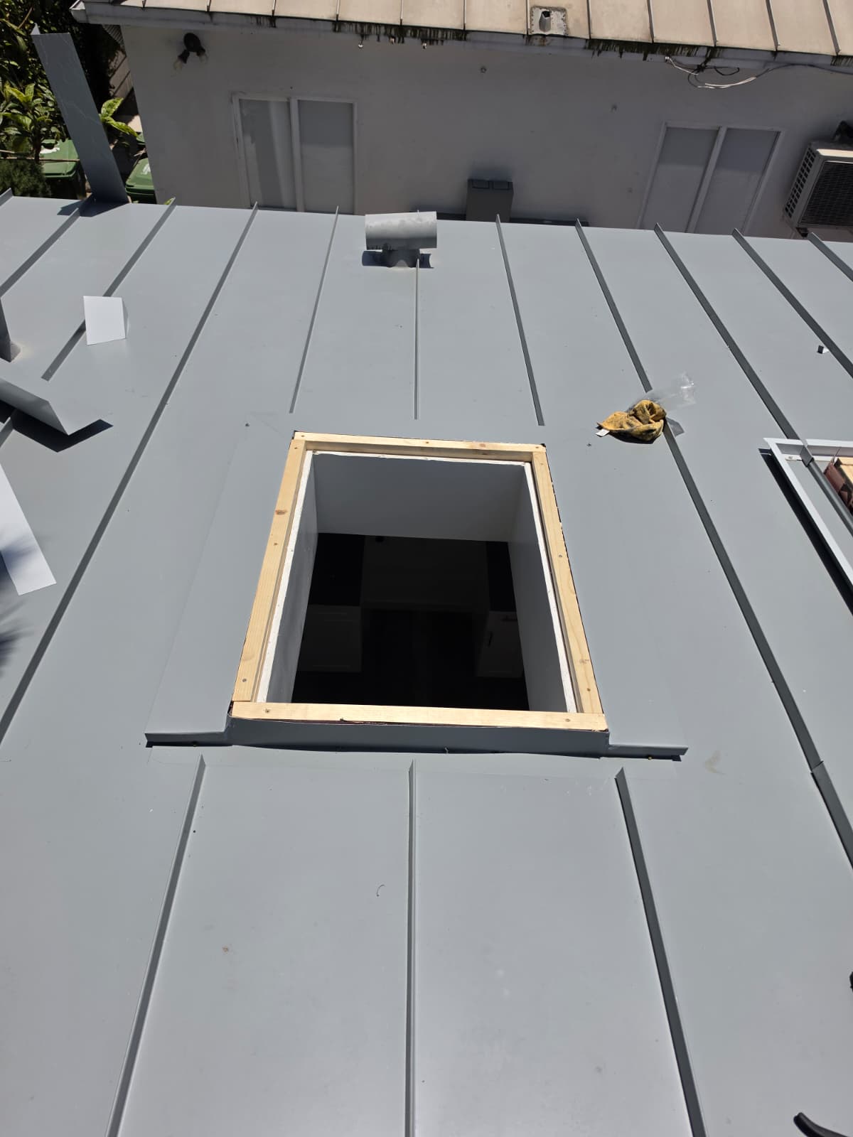 Framed skylight opening cut into a new standing seam metal roof deck
