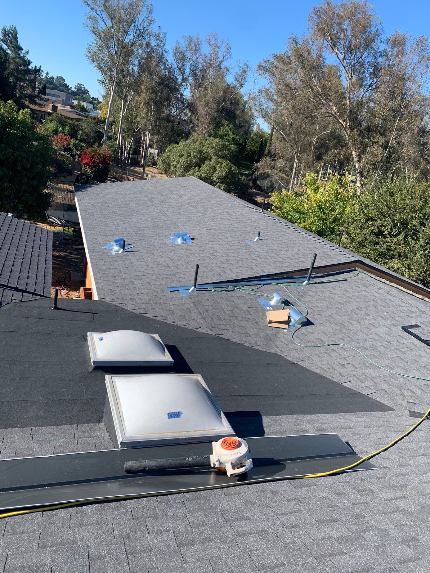 New architectural shingle roof in San Diego with skylights, torch-down low-slope section, and new pipe flashings