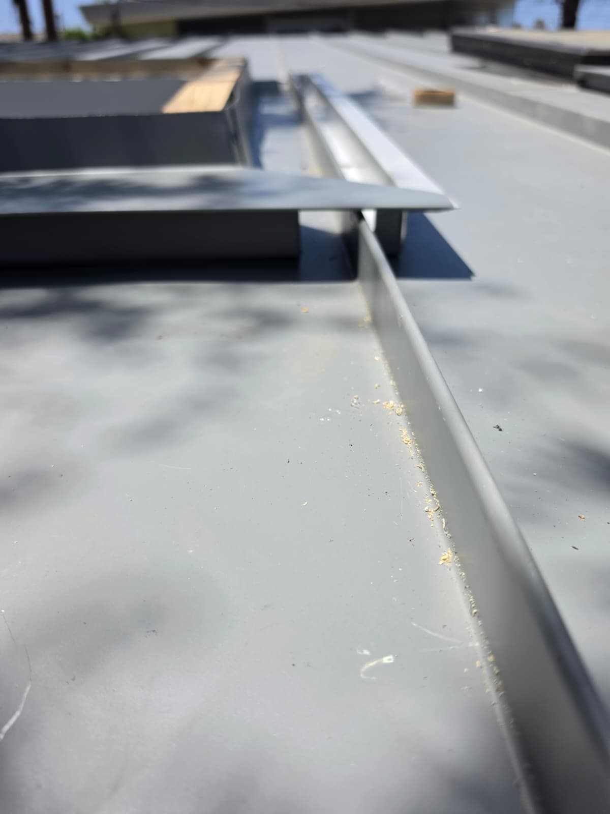 Close-up of a standing seam rib and ridge transition on a metal roof