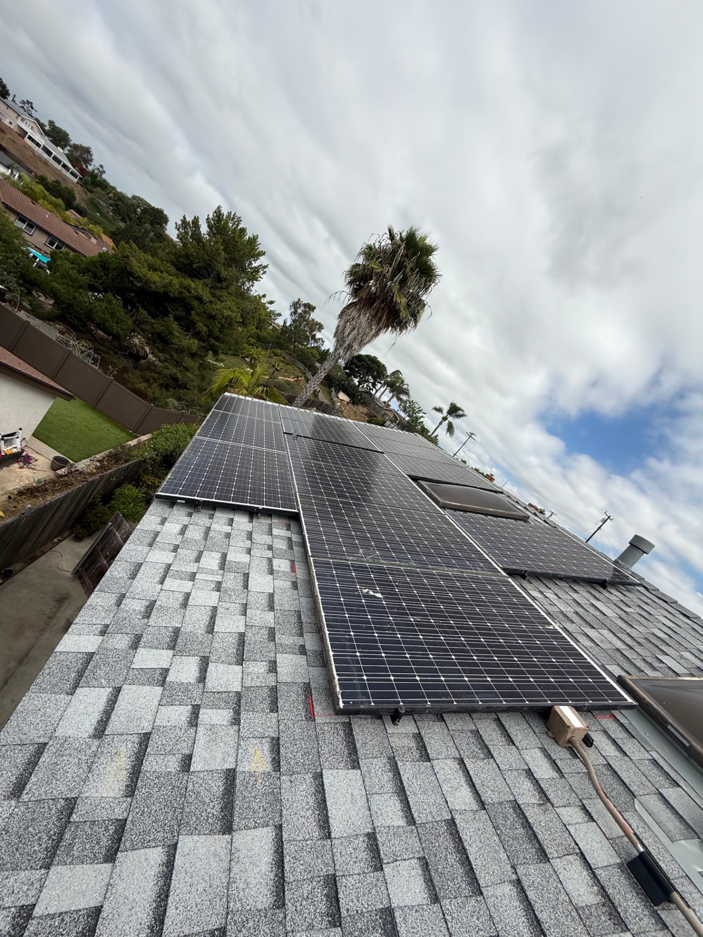 Close view of reinstalled rooftop solar array over new gray asphalt shingles